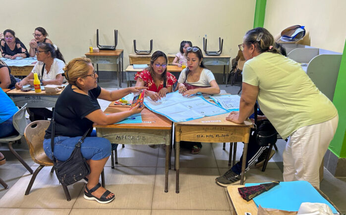Grupo de docentes participando en una dinámica de capacitación en aula durante el inicio del programa Escuelas Indagadoras en Pucallpa.